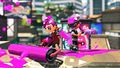 Promotional image of a male Octoling holding the Carbon Roller, and a female holding a Sorella Brella at Arowana Mall.