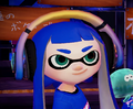 Close-up of a female Inkling wearing the Designer Headphones.