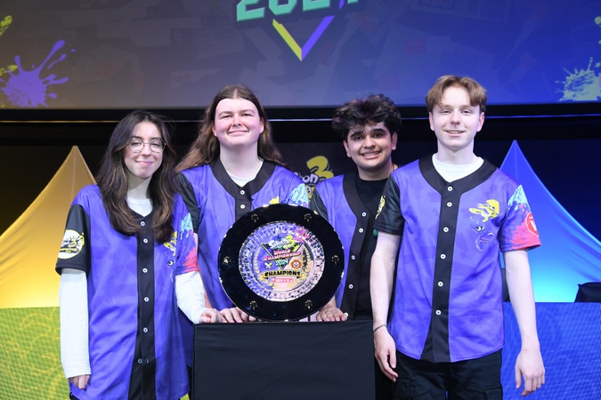 Jackpot members .q, Leafi, Jared, and Madness with the Splatoon 3 World Championship 2024 trophy.