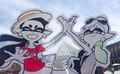 A cut out drawing of Callie and Marie posing in front of the Louvre Pyramid.