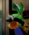 Closeup of a male Inkling wearing the Pilot Goggles, from the side.