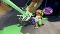 A female Inkling wearing the Baby-Jelly Shirt fires a Heavy Splatling Remix.