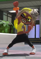 An Inkling performing a Victory Strut while wearing Frye's amiibo gear.