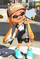 A female Inkling wearing the Black V-Neck Tee.