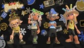 Une Inkling (à droite) portant le chapeau festif anguilles dans une image promotionnelle pour l'équipement du FrostyFest de Splatoon 3.