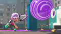An Octoling throwing a Burst Bomb while holding a Splatana Stamper.