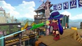 A female Inkling wearing the Camping Hat aims a Bento Splat Charger.