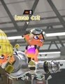 A bronze crown icon above a player's username on the Splatoon 3 match preview spawn screen. The player is holding a Nautilus 47.