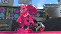 An Inkling transforming from squid form while holding the Custom Range Blaster.