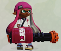 A female Inkling wearing the Traditional Apron, partially obscured by a Heavy Splatling.