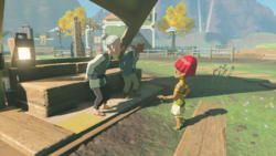 A screenshot of Mattison speaking with Monari at the center of Tarrey Town. Monari's husband, Moggs, stands behind them.