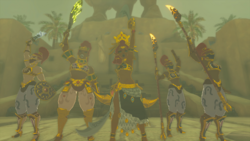 A screenshot of Riju, Buliara, Teake, Ploka, and Reeza raise their Weapons in the air at the center of Gerudo Town.